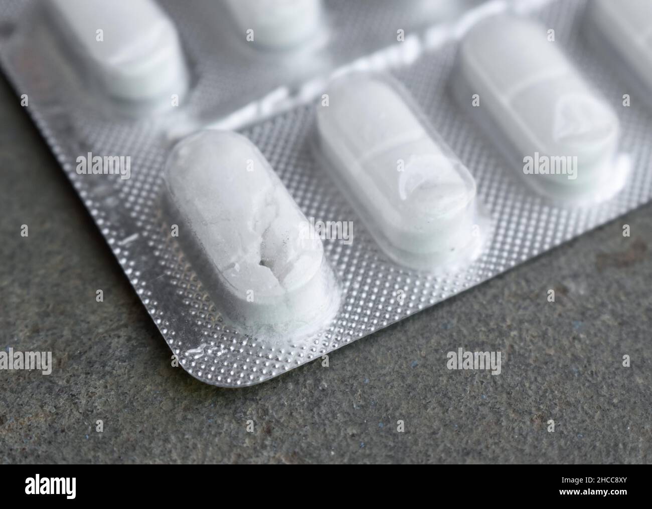 Crushed and damaged tablets in closeup view. Concept of expired drugs