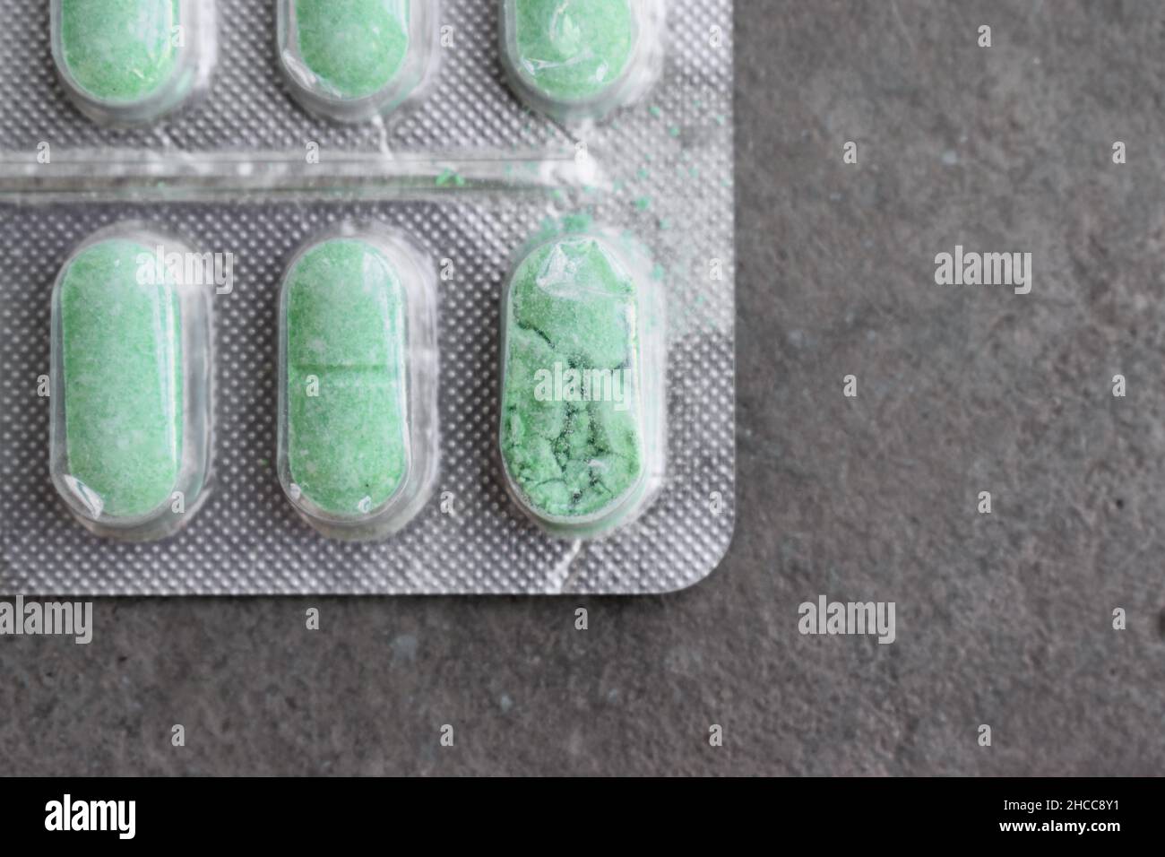 Crushed and damaged tablets in closeup view.  Concept of expired drugs. Stock Photo