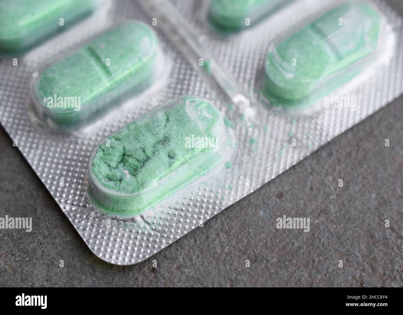 Crushed and damaged tablets in closeup view.  Concept of expired drugs. Stock Photo