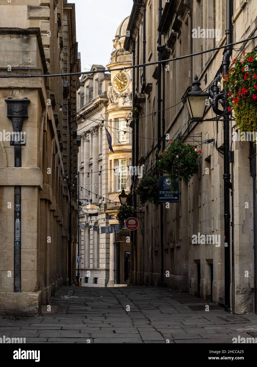 The grand Baroque Midland Bank building is glimpsed between the buildings of St Nicholas Market on Old Post Office Passage in Bristol. Stock Photo