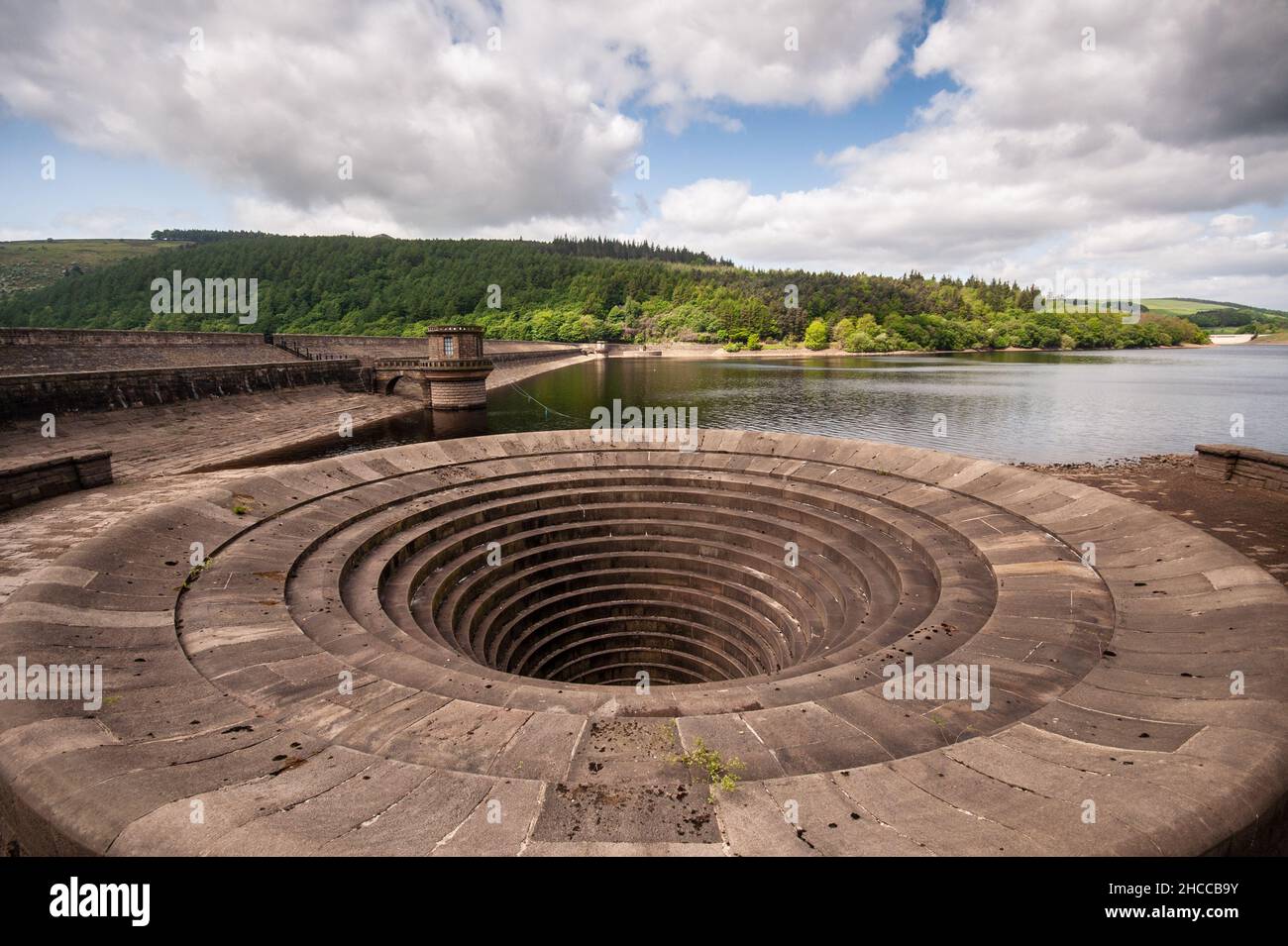 The stone dam and spillway of Ladybower Reservoir in the Derwent Valley, under the hills of Derbyshire's Peak District. Stock Photo