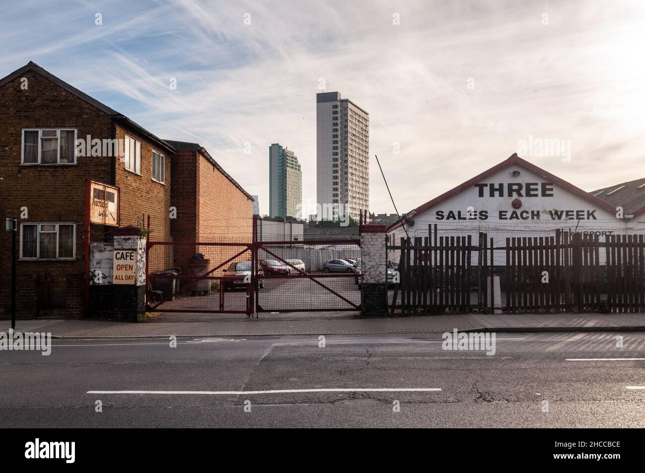 High rise tower block council housing of the Pepys Estate rises behind light industrial Stock Photo