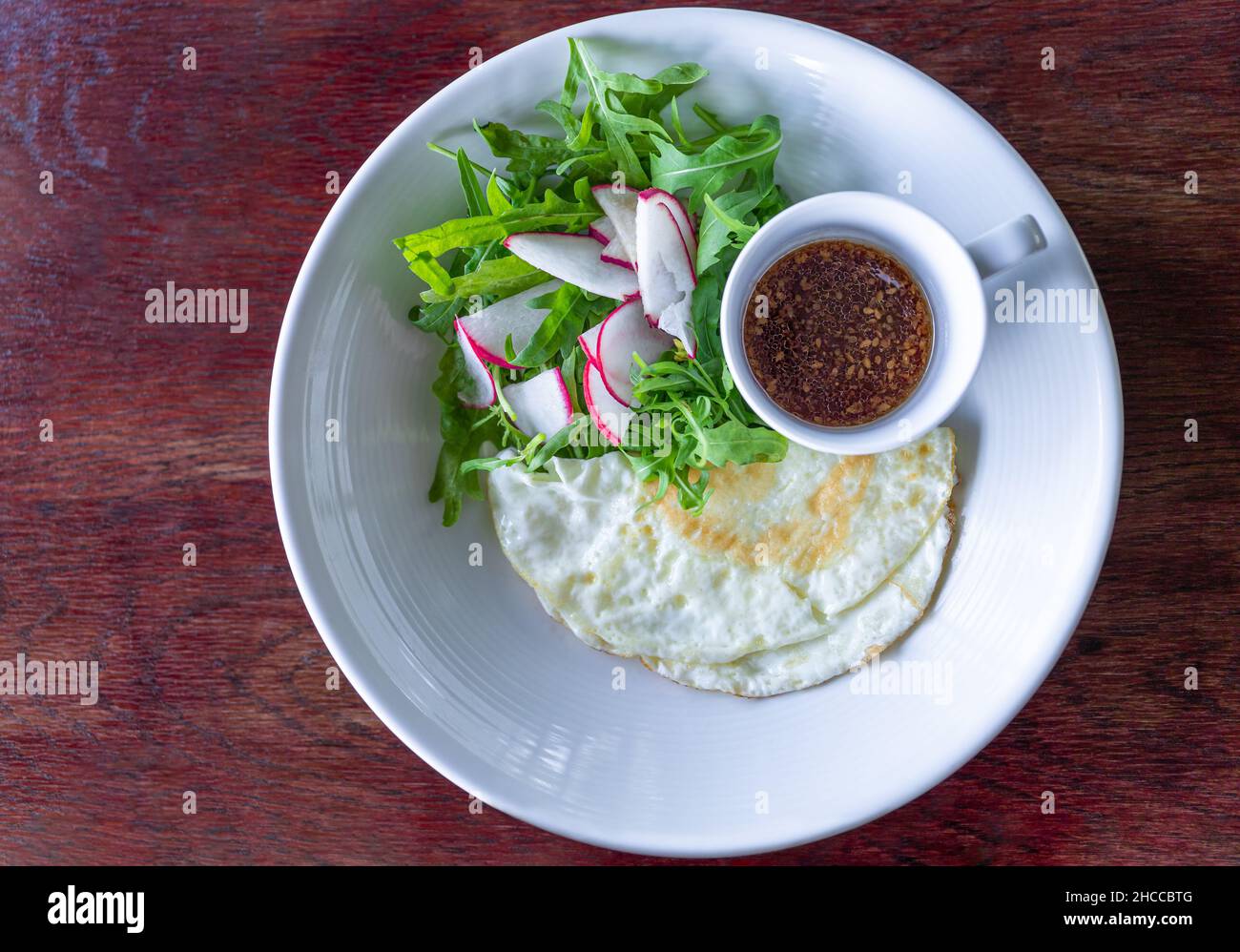 Fried egg white with salad and sesame balsamic dressing healthy breakfast Stock Photo
