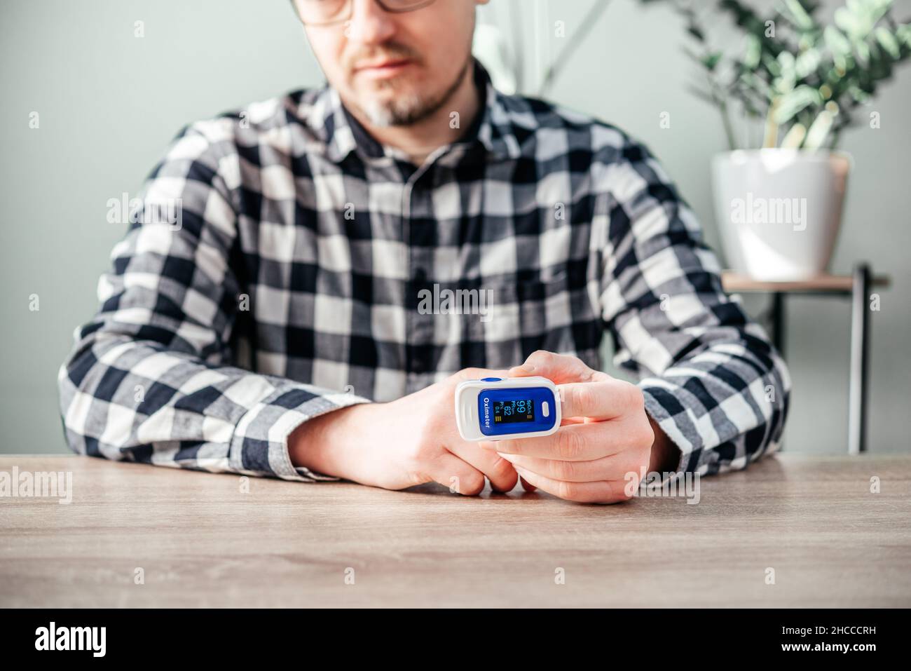 A man checking oxygen level at home with home oximeter, patient