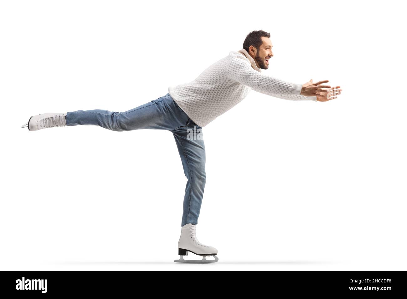 Man in jeans and white knitwear practicing ice skating isolated on white background Stock Photo