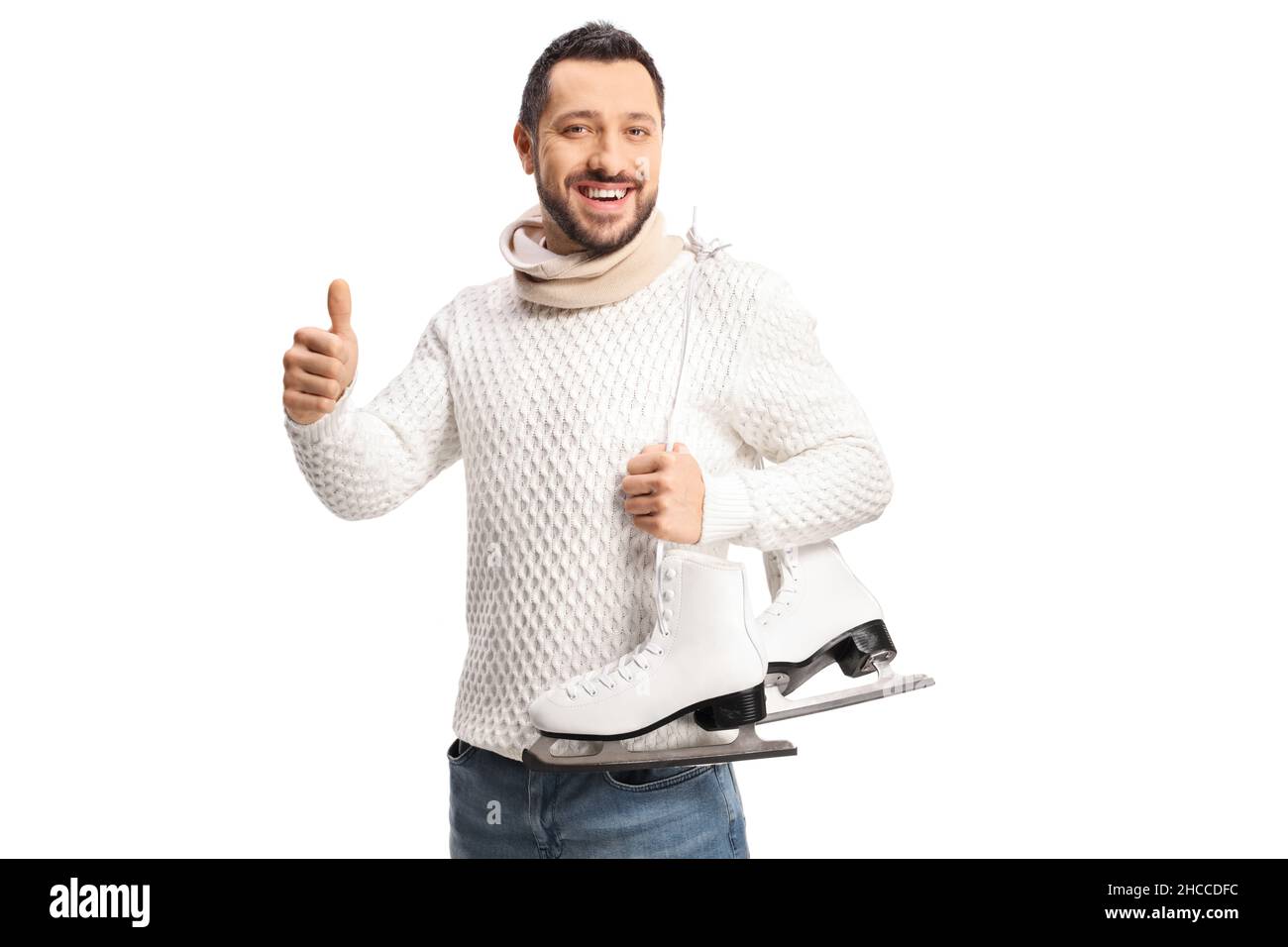 Young man carrying ice skates on shoulder and gesturing thumbs up