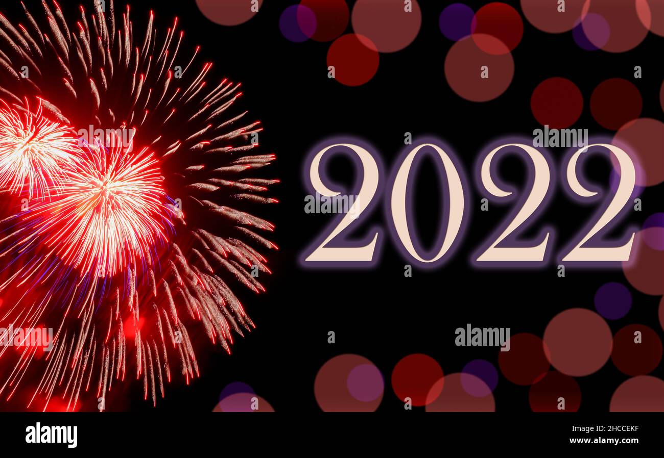 Happy new year 2022, festive red fireworks on background black sky with bokeh and copy space. Concept of holiday Stock Photo