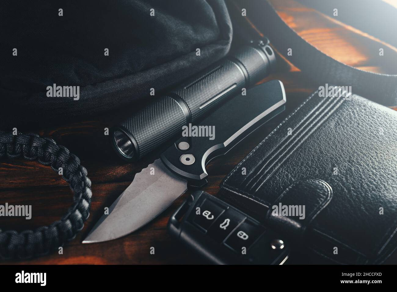 EDC set. Items for Everyday Carry use. Automatic Knife, car keys, paracord bracelet, wallet and tactical bag. Accessories in urban military style for man. Stock Photo