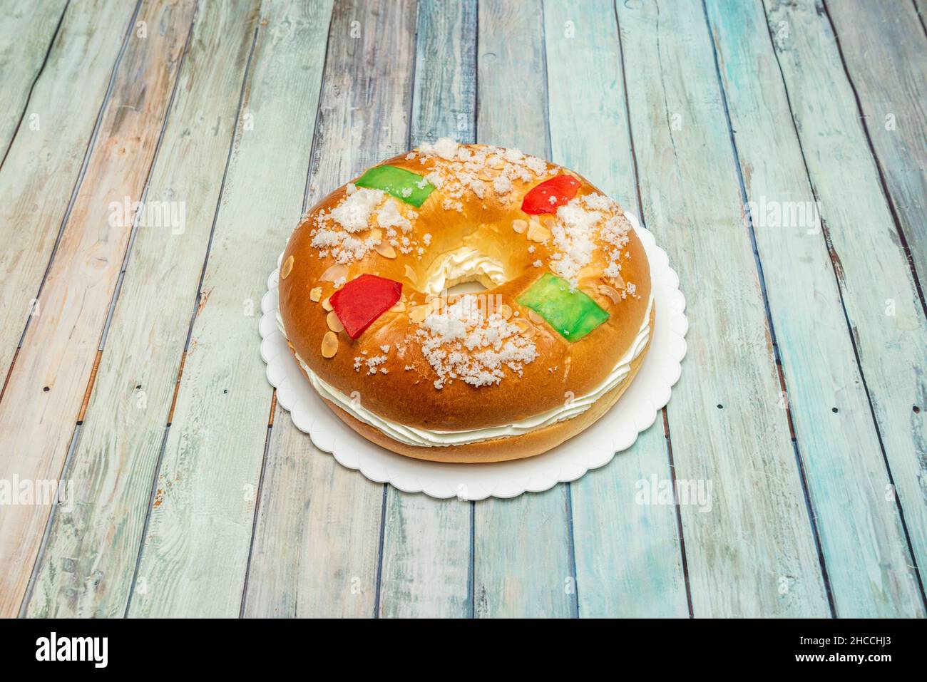 Traditional roscon de reyes stuffed with candied fruits on wooden table Stock Photo
