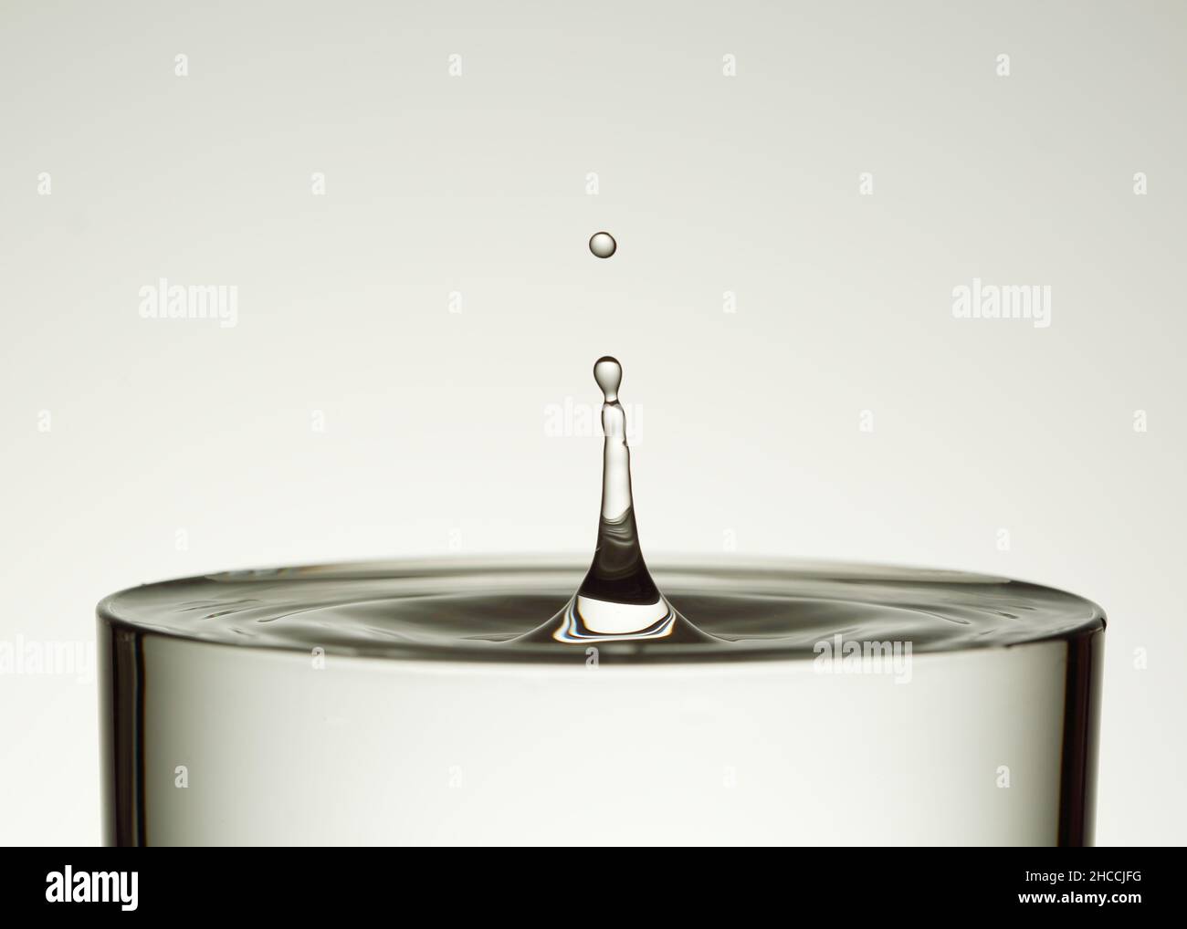 Drop of water splashing into glass macro , transparent, pure water Stock Photo