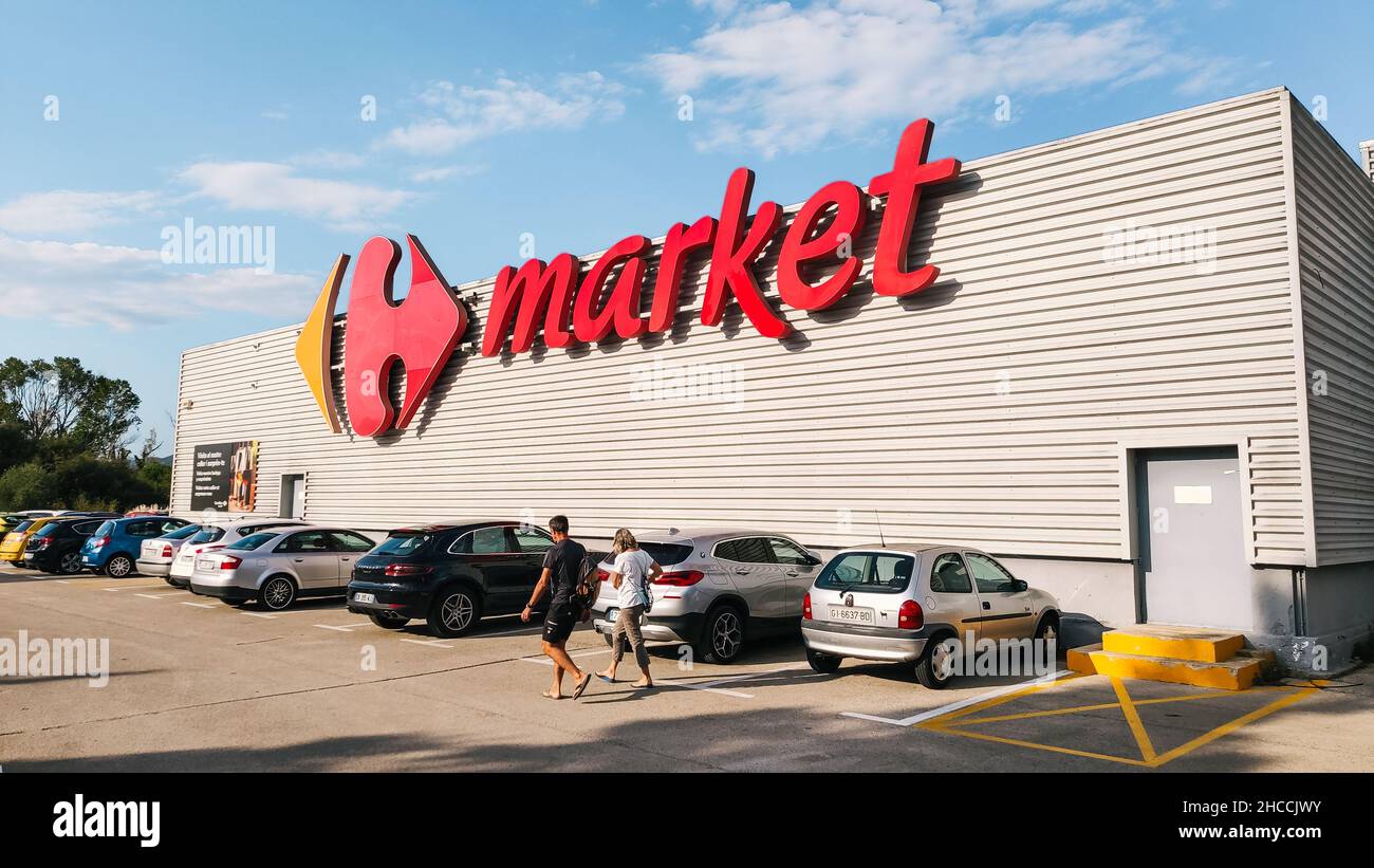 Roses, Spain - September 13, 2021. Carrefour market brand logo, view of the facade and the parking on a sunny day. Carrefour is a popular French hyper Stock Photo