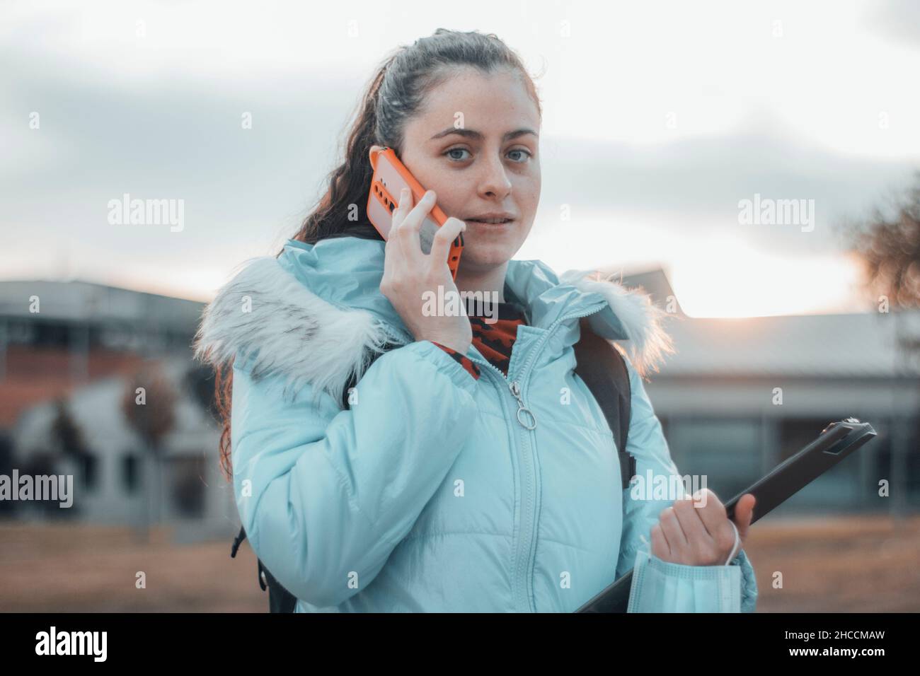 Young girl medical student with calling on mobile phone with smile outside the campus of the faculty Stock Photo