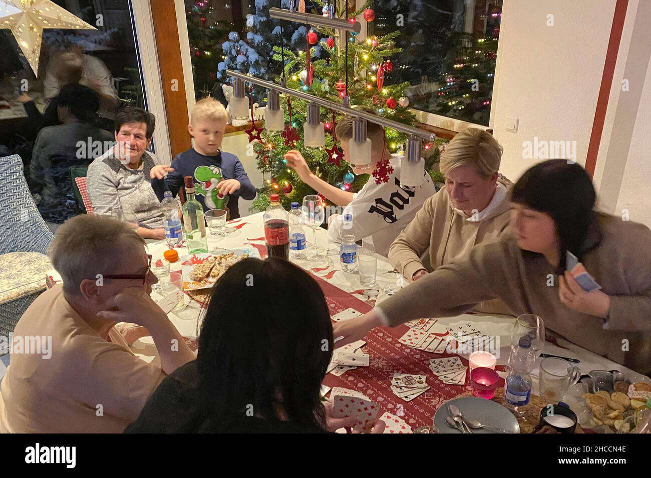 Rudolstadt, Deutschland. 25th Dec, 2021. Family with three generations celebrates Weihafterten 2021 in the Coronavirus with a card game, game evening, games, pandemic, family celebration, Christmas Eve, Weihafterten, Credit: dpa/Alamy Live News Stock Photo
