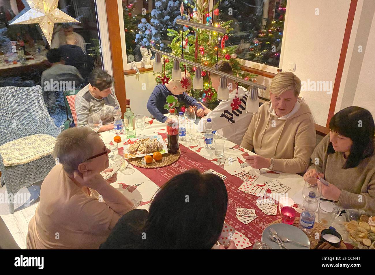 Rudolstadt, Deutschland. 24th Dec, 2021. Family with three generations celebrates Weihafterten 2021 in the Coronavirus with a card game, game evening, games, pandemic, family celebration, Christmas Eve, Weihafterten, Credit: dpa/Alamy Live News Stock Photo