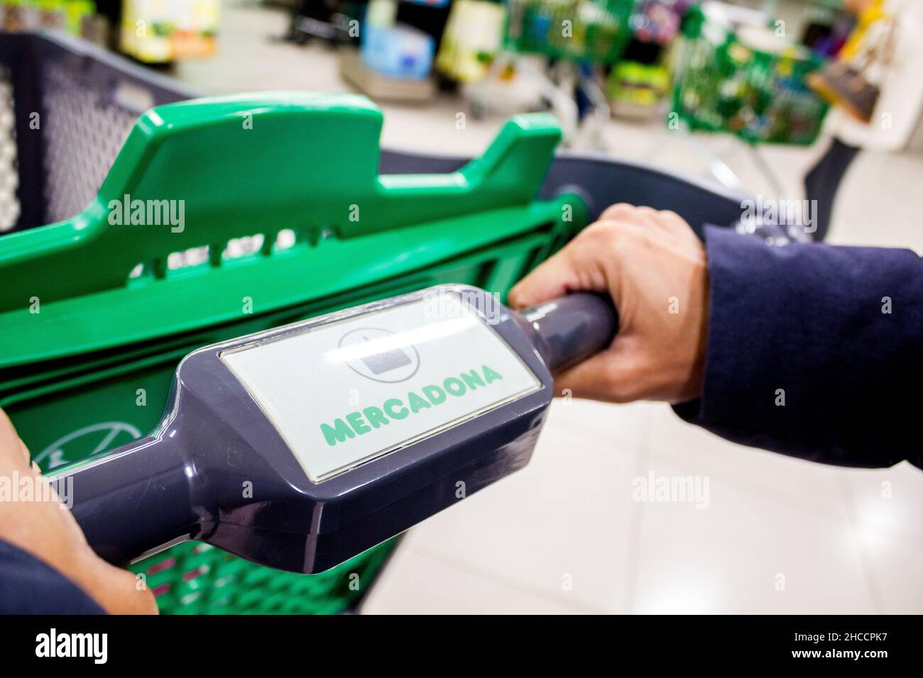 Valencia, Spain; 26th march 2021: A hand holds a shopping cart in a Mercadona supermarket, the most important Valencian hypermarket chain. Stock Photo