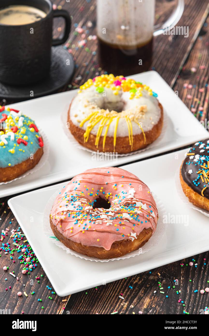 Delicious donuts decorated with different decorations on wooden table Stock Photo
