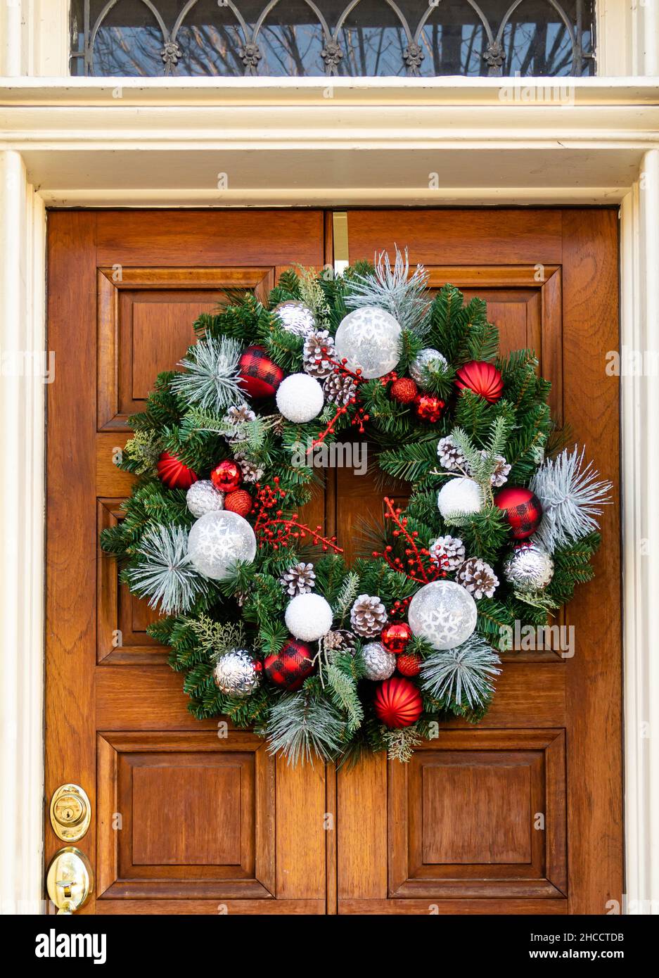 Front door with Christmas wreath, made of pine branches, pine cones and ...