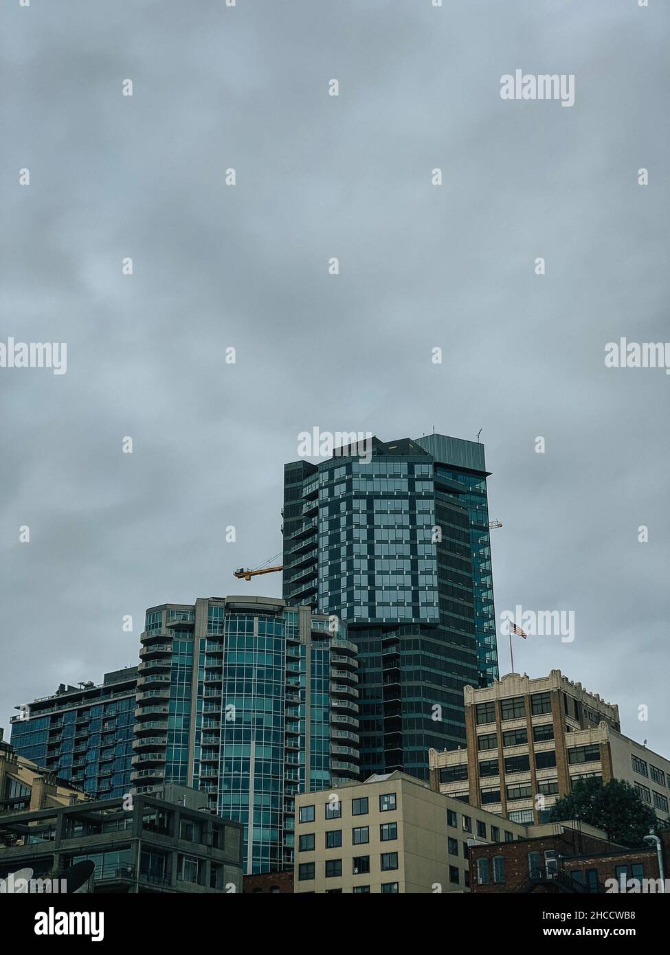 Vertical shot of modern high buildings against a cloudy sky on a gloomy ...