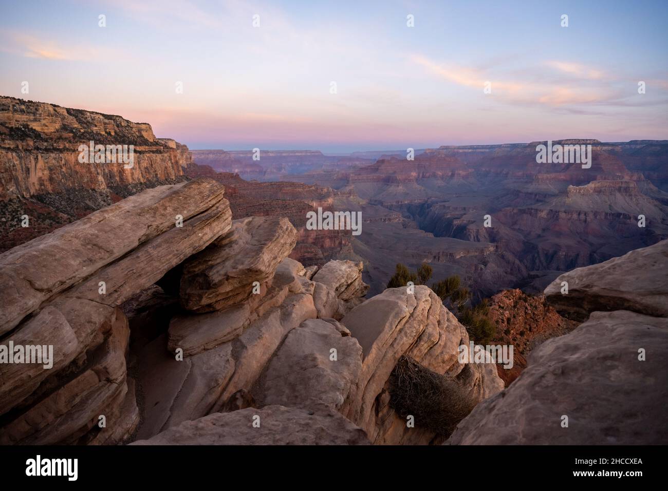 Rocky Outcropping Along The South Kaibab Trail As Sunrise breaks over the Grand Canyon Stock Photo