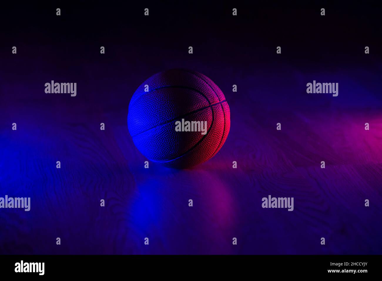 Basketball ball isolated on dark background. Blue neon banner