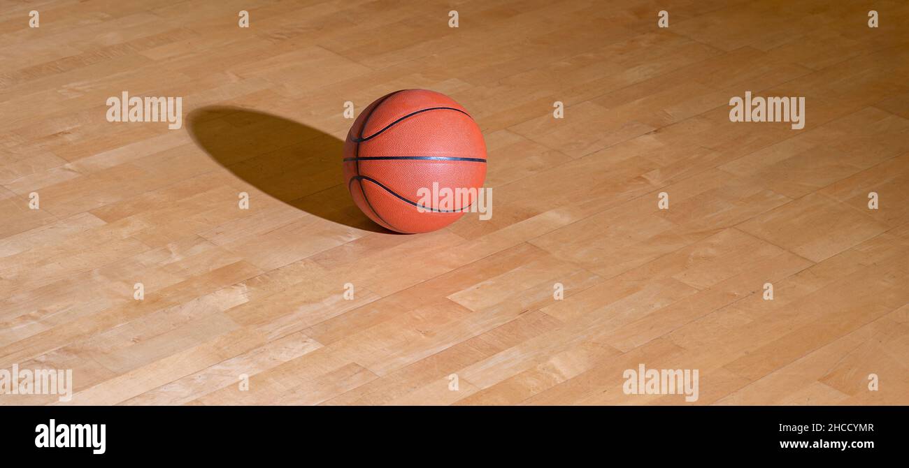 Basketball on hardwood court floor with lighting. Workout online concept. Horizontal sport theme poster, greeting cards, headers, website and app Stock Photo