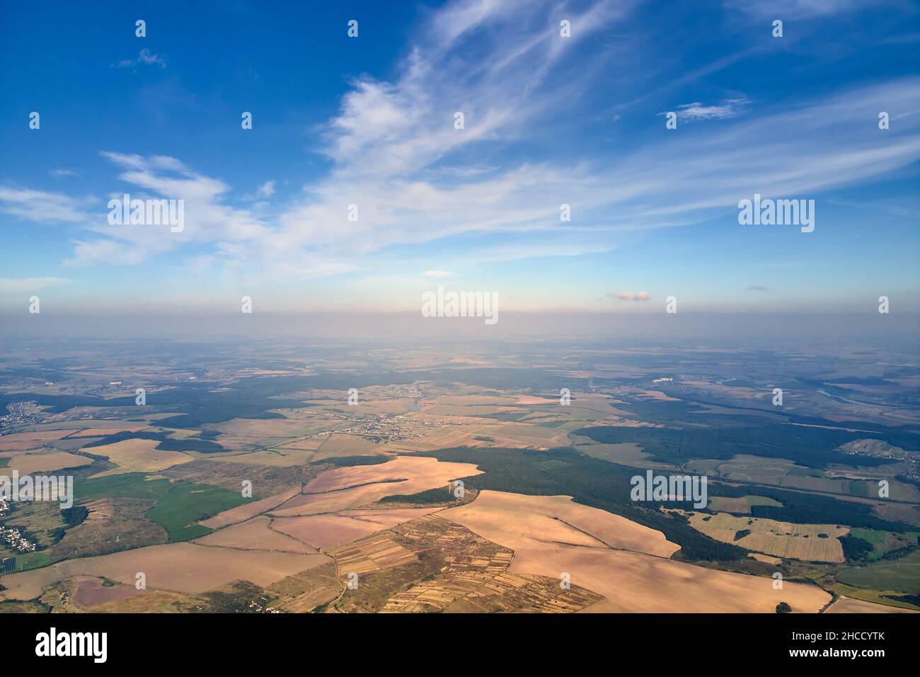 Aerial view of farm fields and distant scattered houses in rural area ...