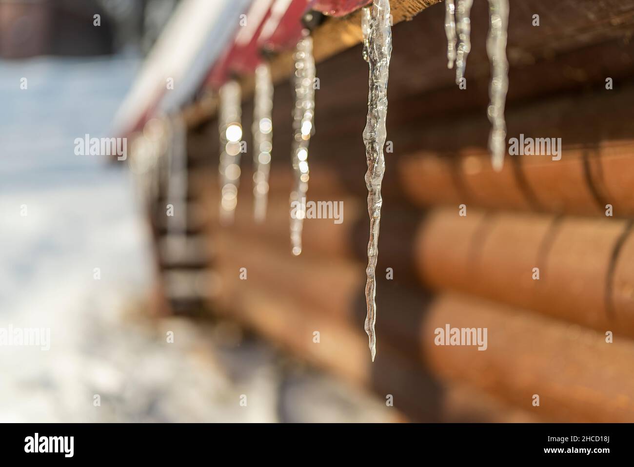 icicles on the roof melt in the spring sun Stock Photo