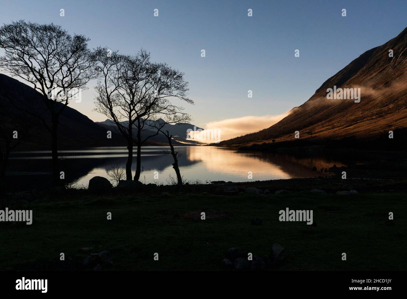 Awesome Blue Sky Scene with tree silhouette in Glen Etive at Loch Etive with reflections, Scottish Highlands Stock Photo