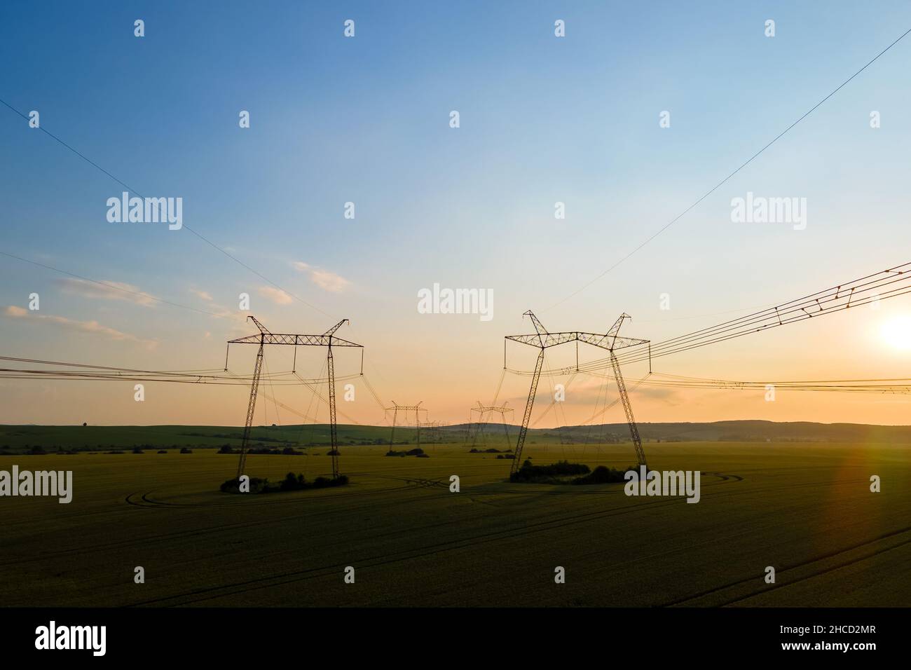 High voltage towers with electric power lines at sunset Stock Photo - Alamy