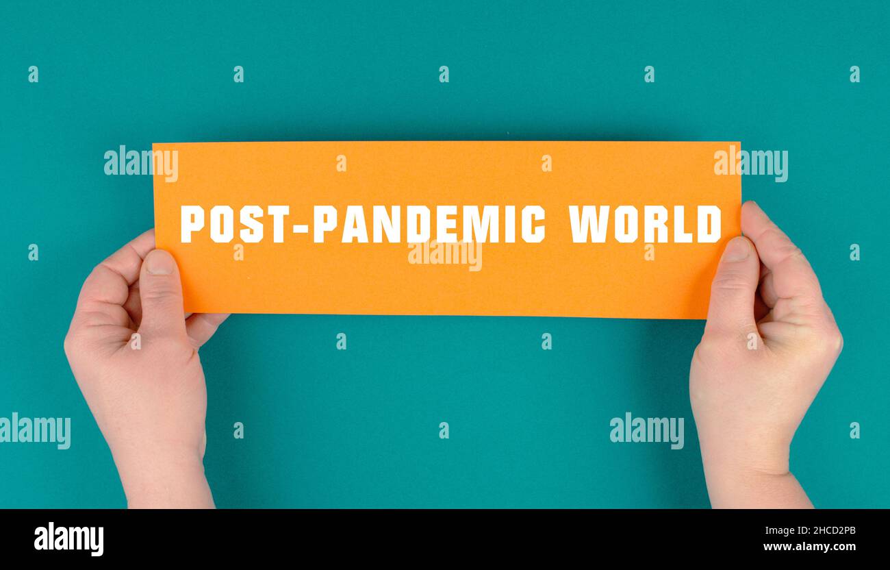 The words post-pandemic world are standing on a paper, life after covid-19, new normal, future lifestayle Stock Photo