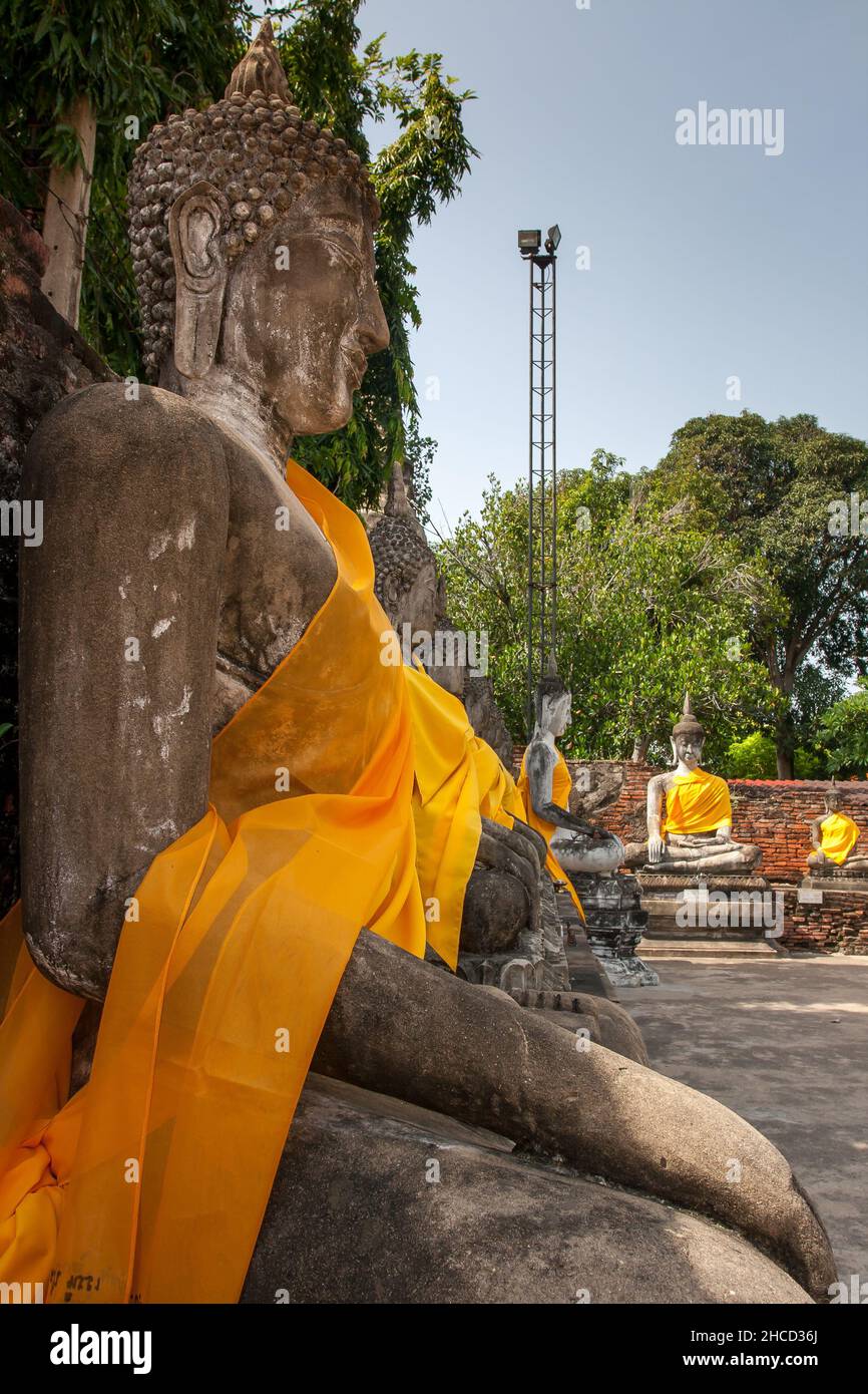 Aligned Sitting Buddha Statues at Wat Yai Chaimongkol in Ayutthaya, the 13 century historic capital of Kingdom of Siam, Thailand Stock Photo