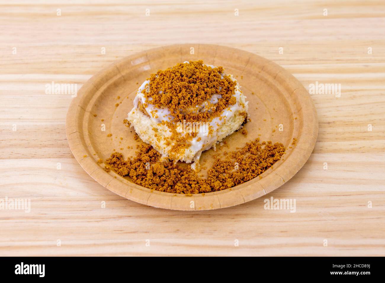 Delicious cinnamon roll with sugar coating and white chocolate with cookie ground on top Stock Photo