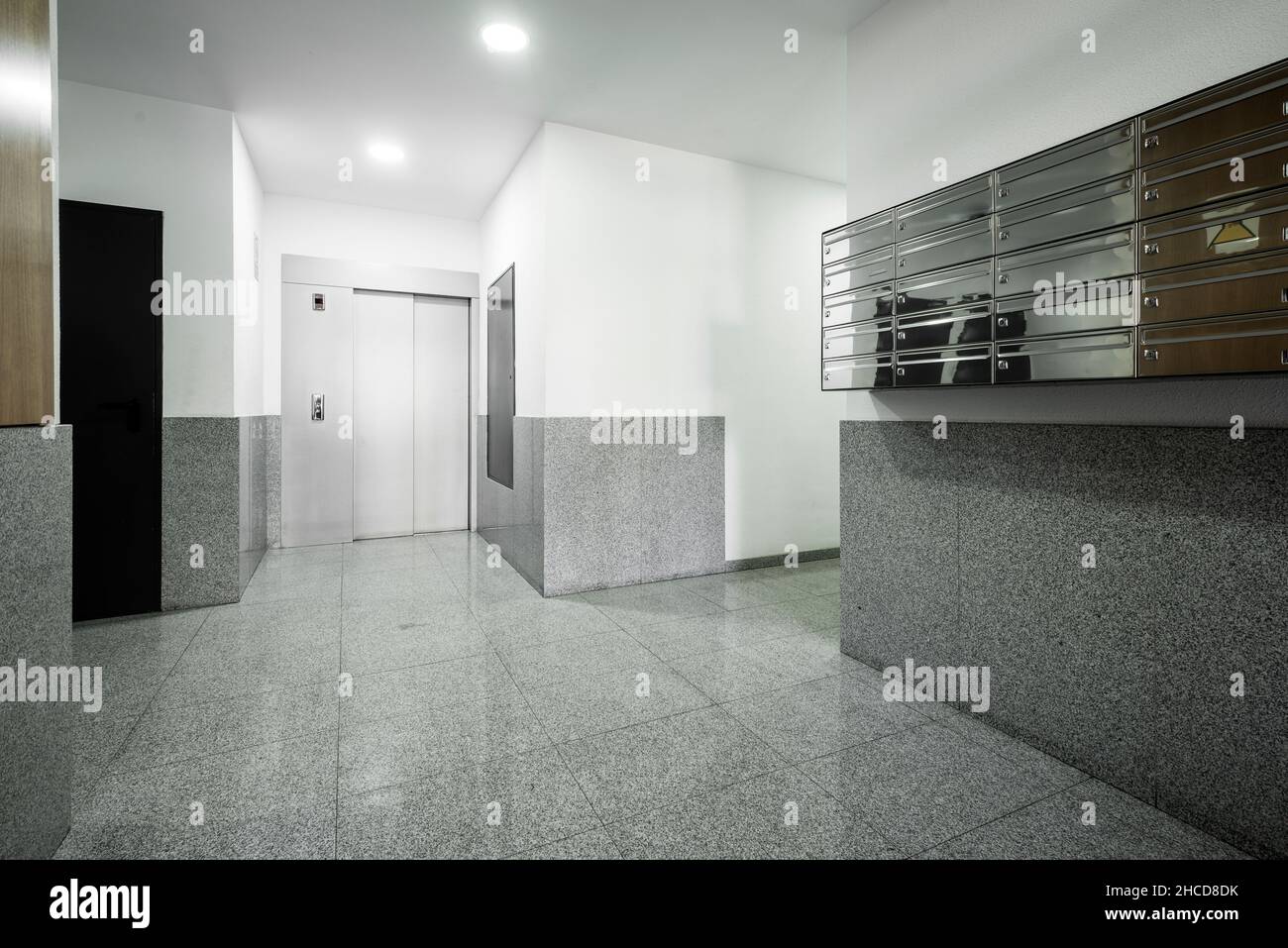 Building portal with metal mailboxes, granite floors and gray elevator in the background Stock Photo