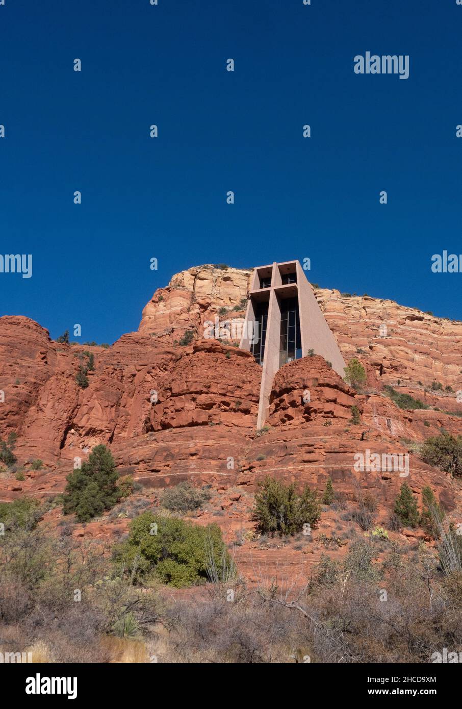 Roman Catholic Chapel of the Holy Cross built into an orange sandstone cliff in Sedona, Arizona, with brilliant turquoise sky above. Stock Photo