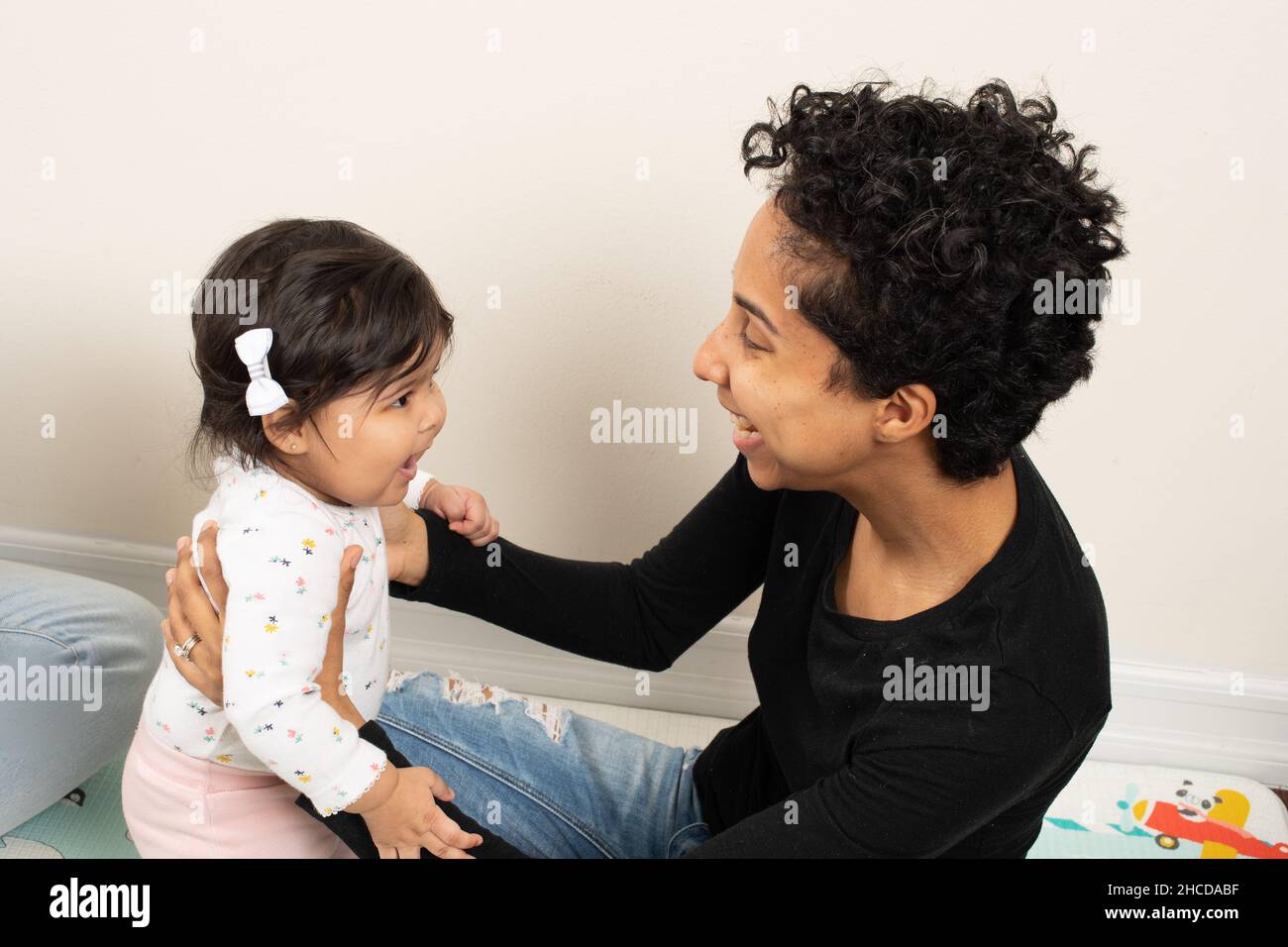 8 month old baby girl smiling interaction with mother Stock Photo