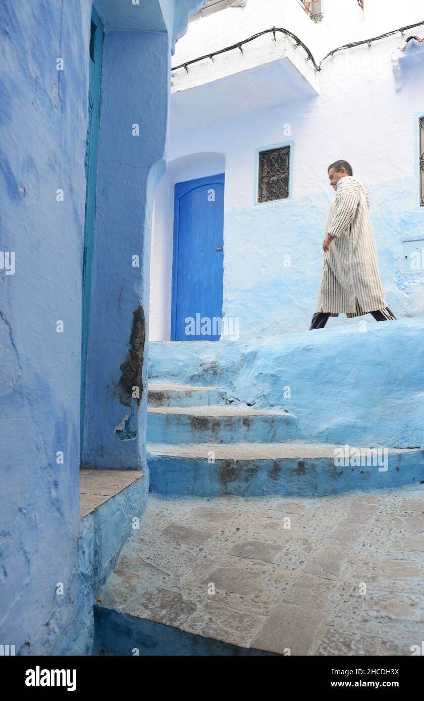 A local man walking through the narrow streets of the medina of Chefchaouen, Morocco. Stock Photo