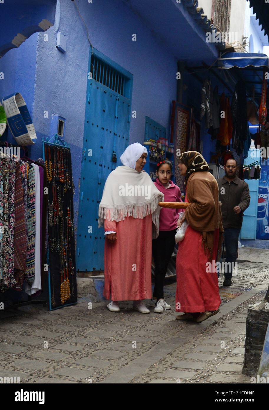 Local Moroccan women walking through the narrow streets of the medina of Chefchaouen, Morocco. Stock Photo