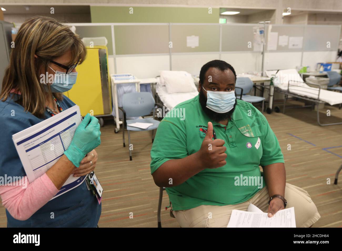 February 25, 2021: African American veteran and security officer Robert Mack, right, gives a thumbs in the observation area, while RN Deb Simpson, left, looks on at the Veterans Affairs San Diego Healthcare System in La Jolla, California, U.S., December 27, 2021. Zuma PressRishi Deka (Credit Image: © Rishi DekaZUMA Press Wire) Stock Photo
