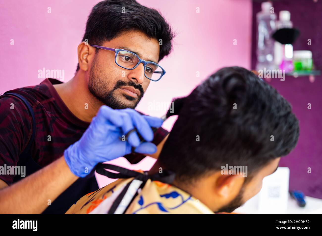 Close up shot of hairdresser busy in haircut at salon - concept of haircare, professional occupation and small business. Stock Photo