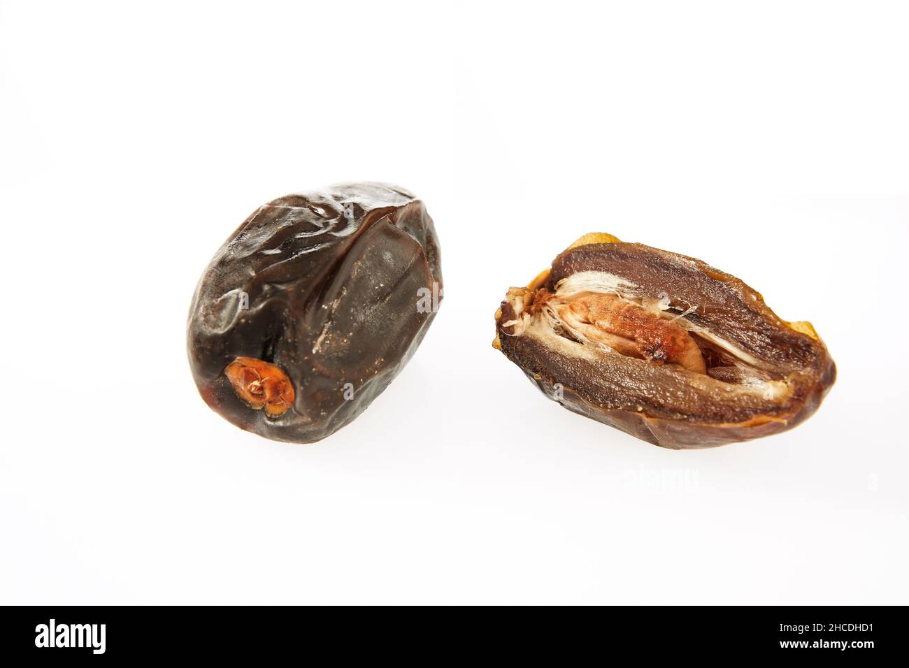 Fresh whole and half dates isolated on white background. Stock Photo