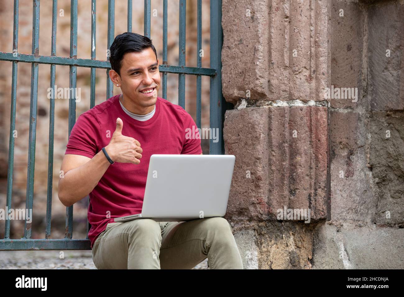 Young latino men with laptop on the street, Panama City, Central America Stock Photo