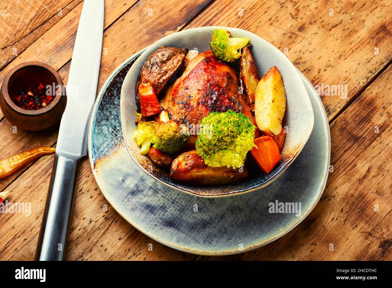 Chicken thighs roasted with potatoes, quince and broccoli Stock Photo