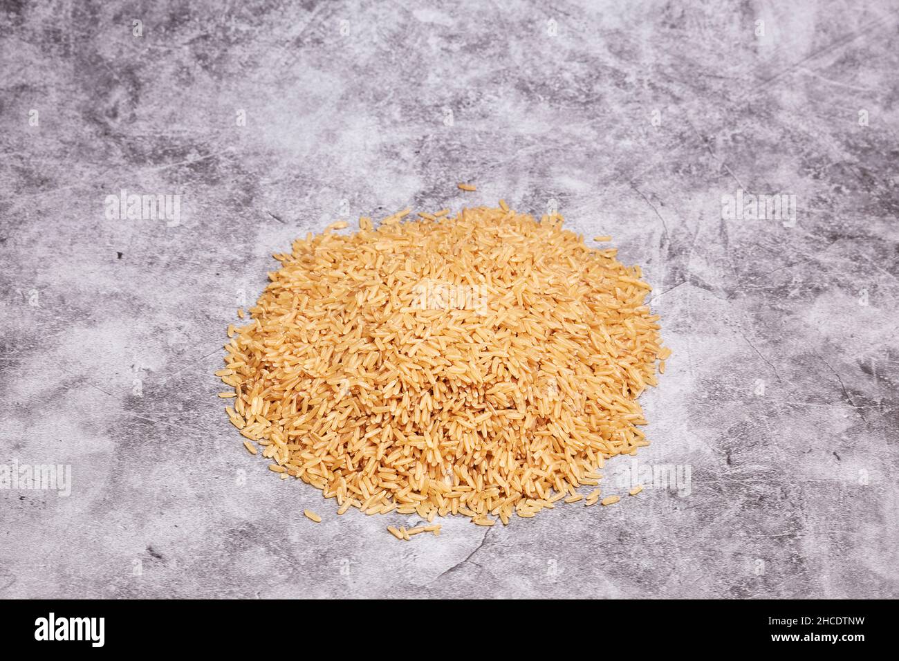 Pile of uncooked rice on a gray stone background. Asian food. Healthy food concept Stock Photo