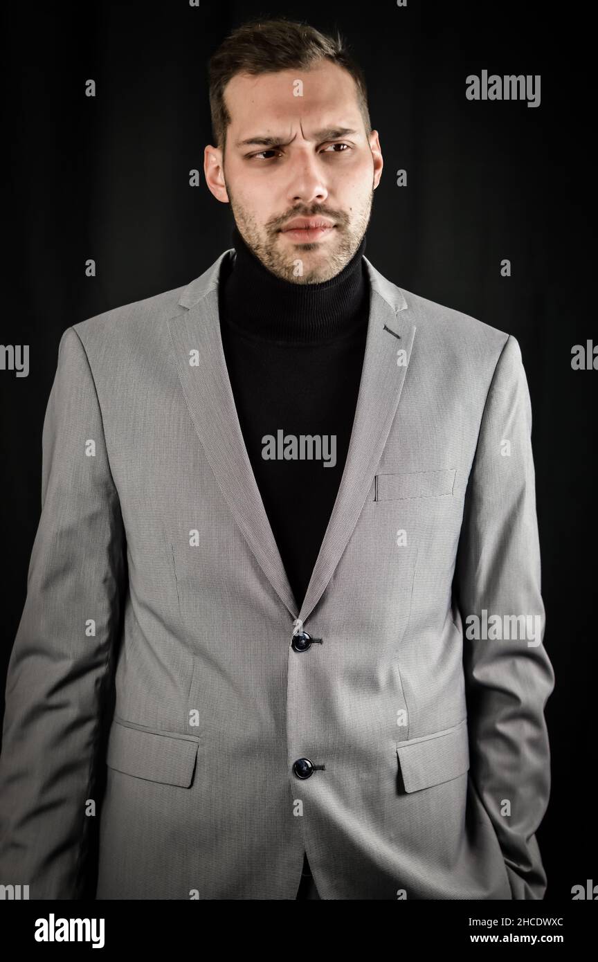 portrait of a young businessman in a gray suit and black turtleneck ...