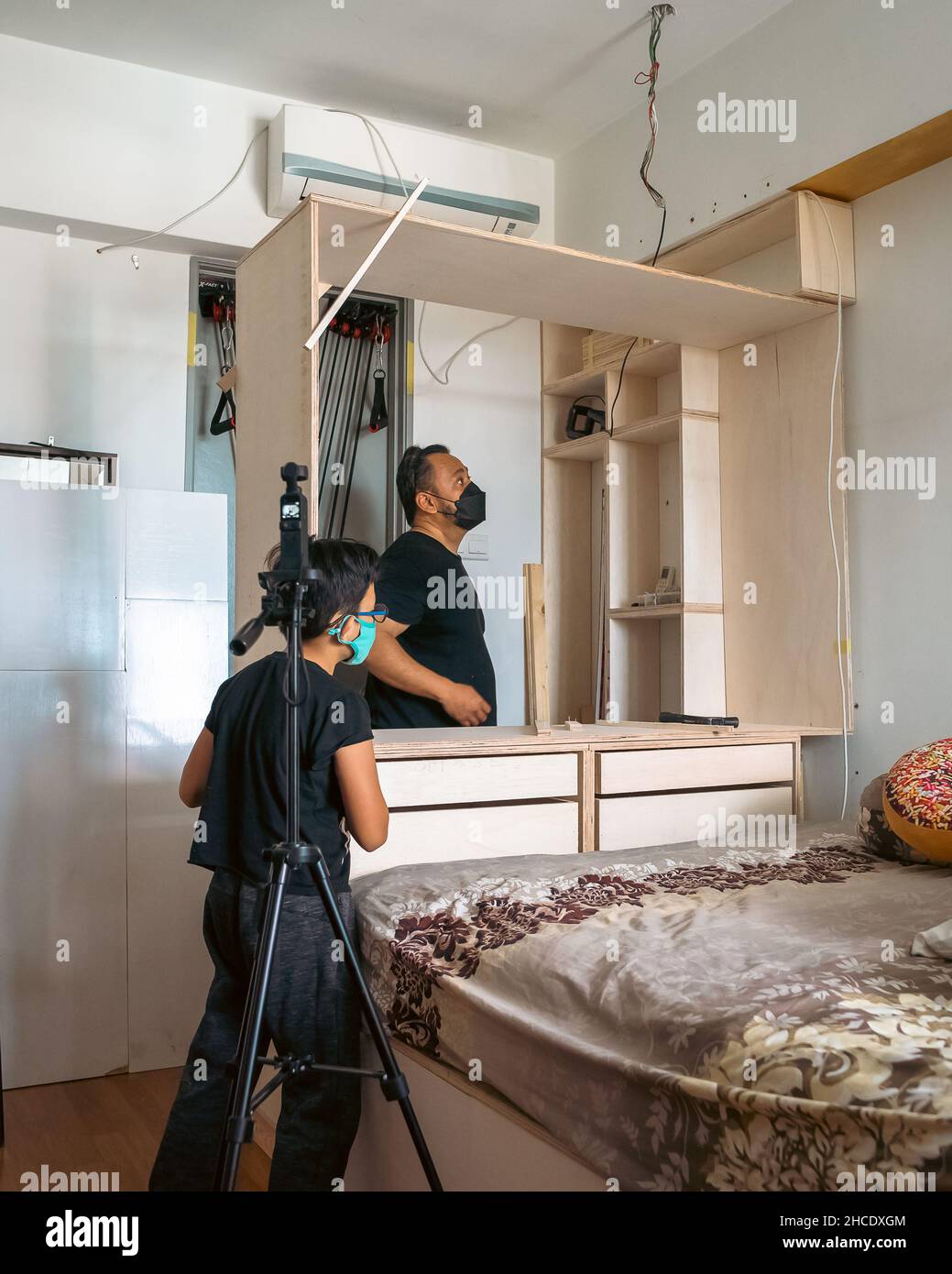 Wardrobe assembly in progress. DIY at home. Father and son Stock Photo