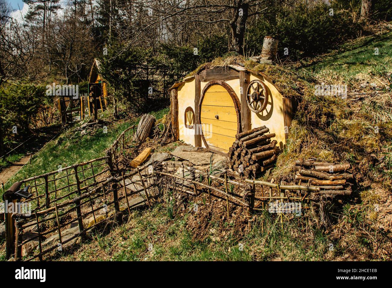 Hobbit house in Czech Hobbiton with three Hobbit holes and cute yellow doors.Fairy tale home in garden.Magic small village from fantasy movie Stock Photo