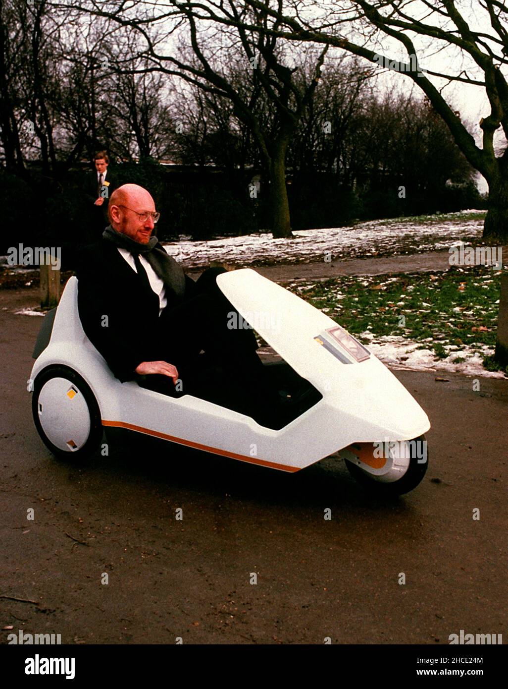File photo dated 10/01/85 of Sir Clive Sinclair demonstrating his C5 electric vehicle, the battery-come-pedal powered trike, at Alexandra Palace. Home computing pioneer Sir Clive Sinclair died in 2021. Issue date: Tuesday December 28, 2021. Stock Photo