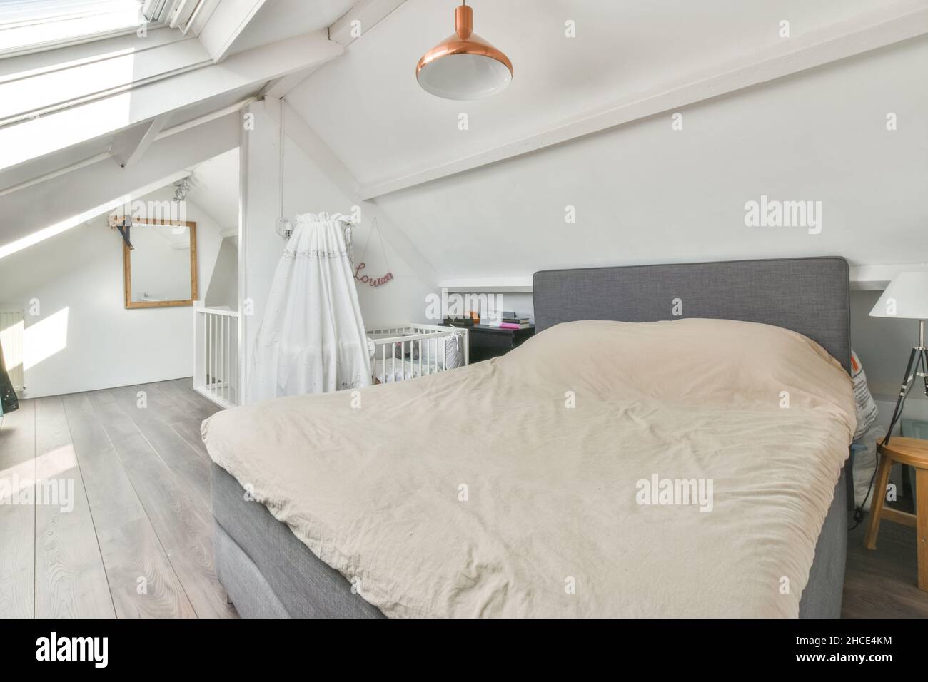 Interior of modern white bedroom furnished with comfortable bed placed