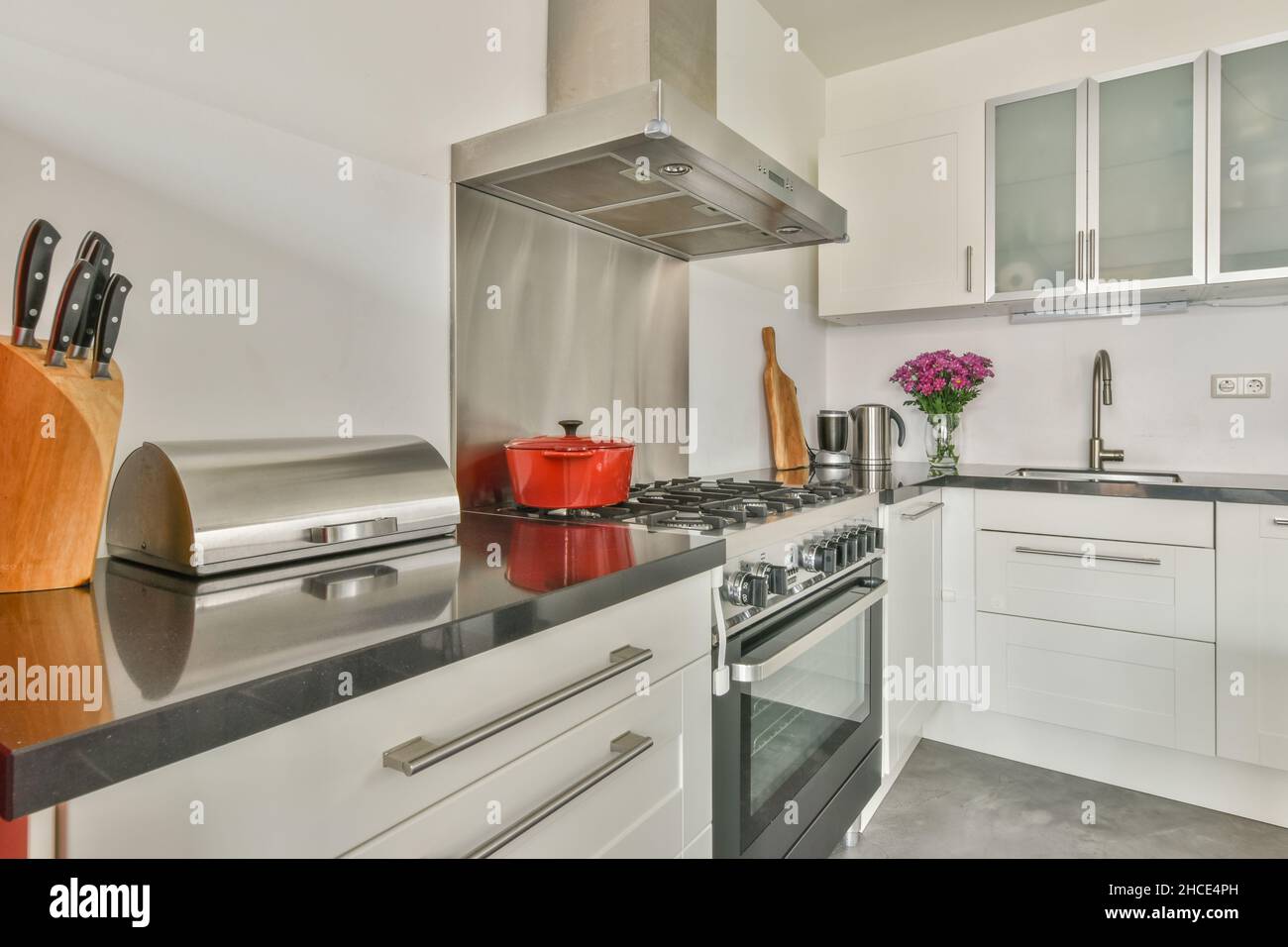 Light kitchen interior furnished with counter with gas stove and oven ...