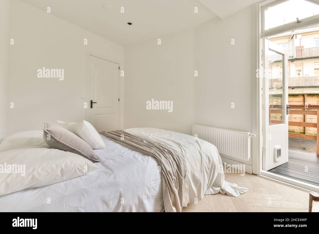 Comfortable bed with pillows and blanket and on the other side a ...